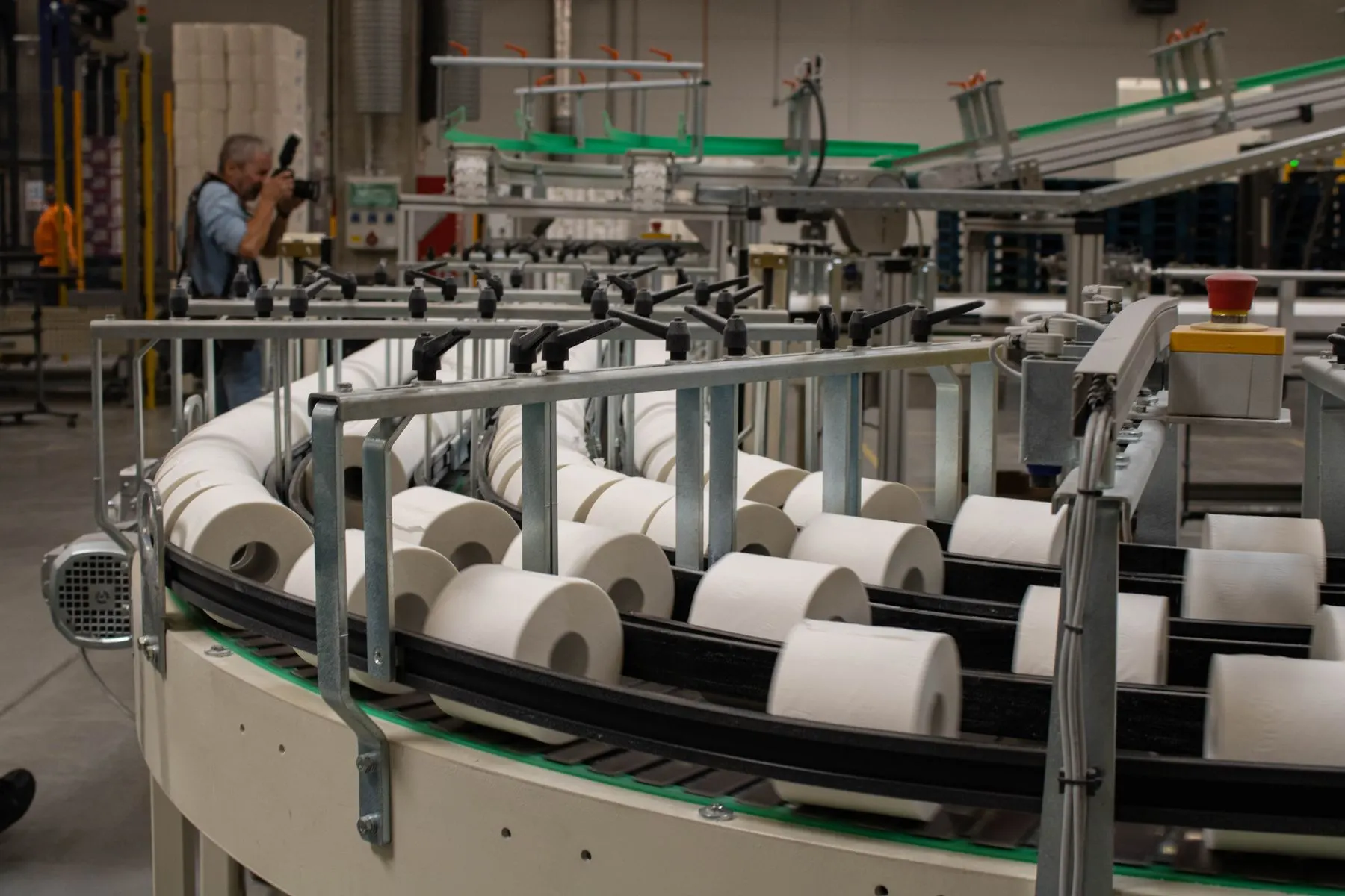 Rolls of bath tissue moving along a converting line