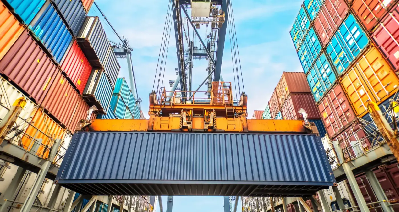 Shipping container lifted by a gantry crane at port